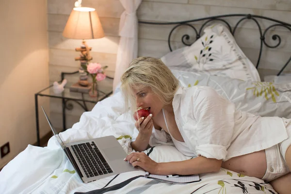 Tânăra Însărcinată Stă Întinsă Într Pat Folosind Laptopul Mâncând Măr — Fotografie, imagine de stoc