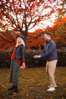 Erkek ve kadın. Sonbahar. Park et. Bir adam düşen bir kadını yakalar.