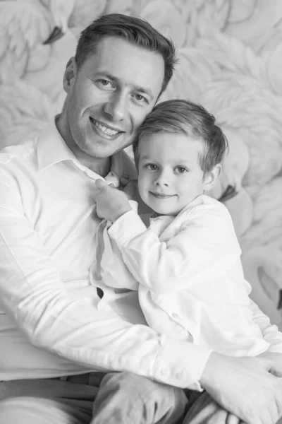 Family. Father and son sitting together. A happy family. Black and White. Smile. Background.