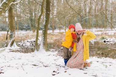 Şapkalı anne ve oğlu gözlerini kapatmış. Ormandaki arka plan.