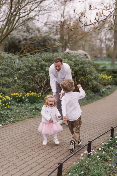 愛する父は彼の子供たちと公園で遊んで楽しんでいます — ストック写真