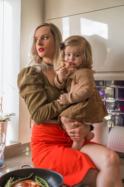 Jonge Moeder Houdt Haar Dochtertje Schoot Terwijl Het Tafelblad Keuken — Stockfoto