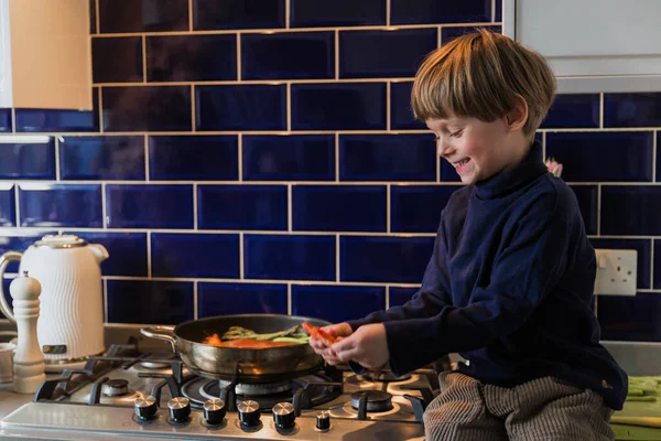 幸せなブロンドの少年 調理に役立ちます 魚介類 — ストック写真