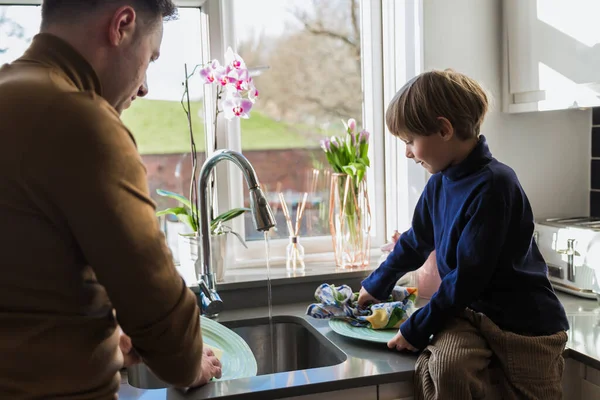 幼い父親が息子と一緒に皿を洗う 子育て コミュニケーション — ストック写真