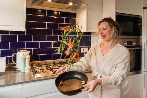 Une Jeune Femme Blonde Jette Des Asperges Avec Des Crevettes — Photo