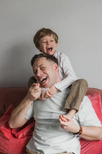 Alegre Padre Dando Hijo Piggy Back Mientras Está Sentado Sofá — Foto de Stock