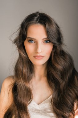 Genç esmer bir kadının portresi, model, büyüleyici bir görünüş, kameraya bakıyor..