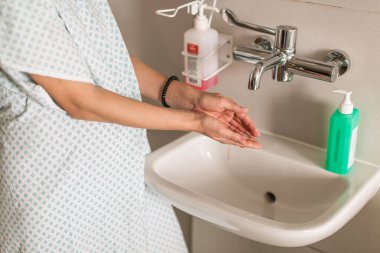 Doğum hastanesinde hamile bir kadın lavaboda el yıkadı..