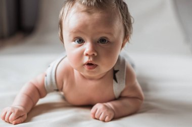 Sarışın, tatlı bir kız. Uzanmak. Kameraya bakıyorum. İlginç bir bakış. Hafif bir arkaplanda.