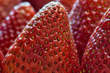 Seçici odaklı olgun çilek makrosu ve ön planda ince detaylar, tam çerçeve resmi.