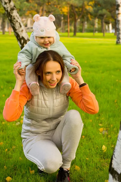 Jonge moeder met haar kinderen in het najaar park — Stockfoto