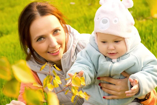 Jonge moeder met haar kinderen in het najaar park — Stockfoto