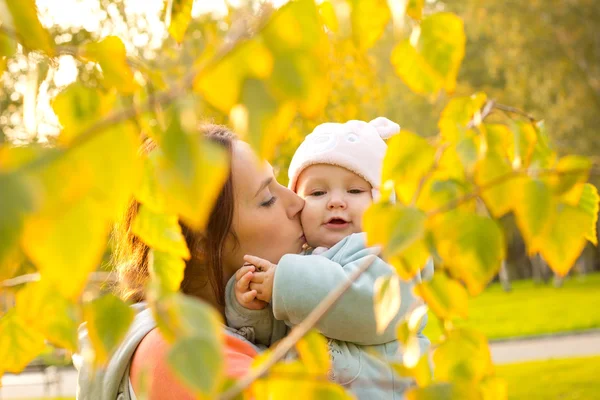 Jonge moeder met haar kinderen in het najaar park — Stockfoto