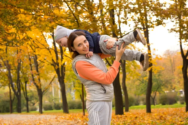 Jonge moeder met haar kinderen in het najaar park — Stockfoto