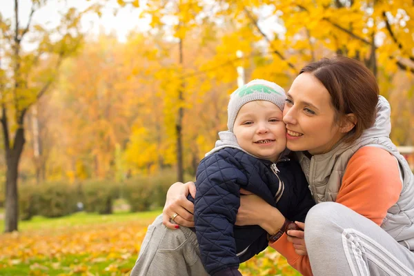 Jonge moeder met haar kinderen in het najaar park — Stockfoto