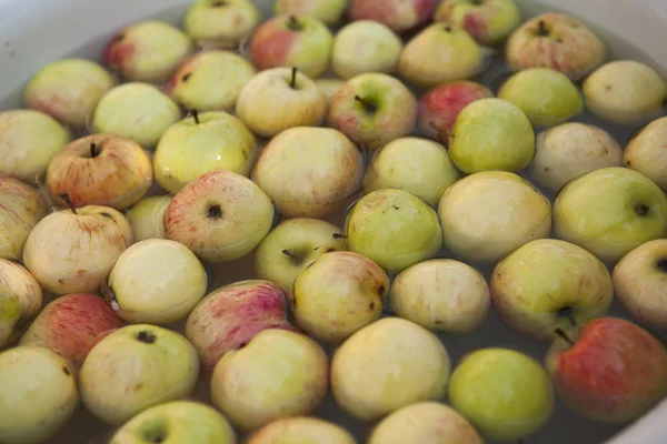 Cleaning apples in the bowl with water — Stock Photo, Image