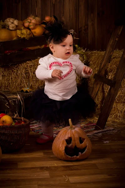 Little baby girl on Halloween party with pumpkin — Stock Photo, Image