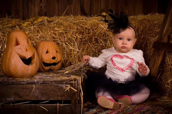 Маленькая девочка на вечеринке Хэллоуина с тыквой — стоковое фото