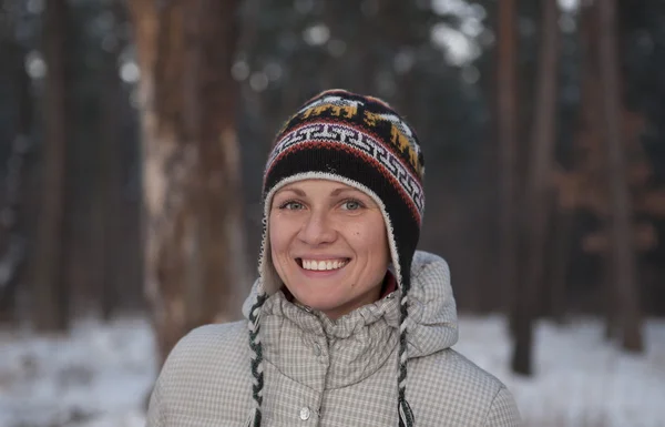 Portrait of playful woman in knitted winter cap smiling — Stock Photo, Image