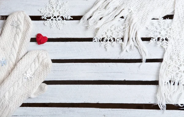 White mittens and scarf on a wooden plank background with copy space — Stock Photo, Image