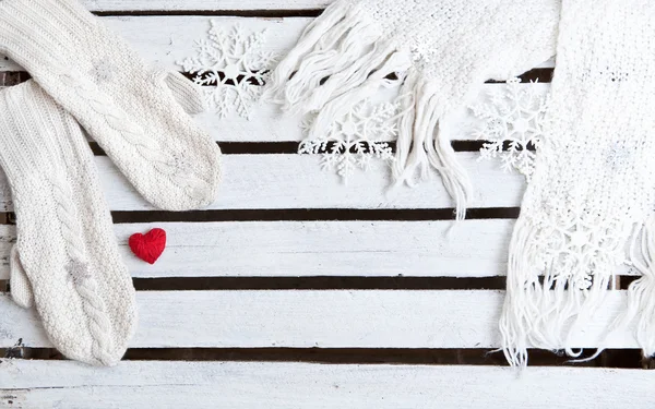 White mittens and scarf on a wooden plank background with copy space — Stock Photo, Image