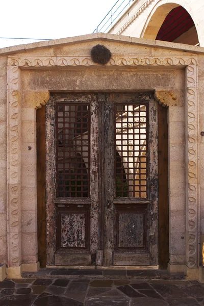 Ancient wooden door in stone castle wall — Stock Photo, Image