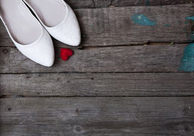 düğün ayakkabıları ve ahşap arka plan üzerinde kırmızı kalp