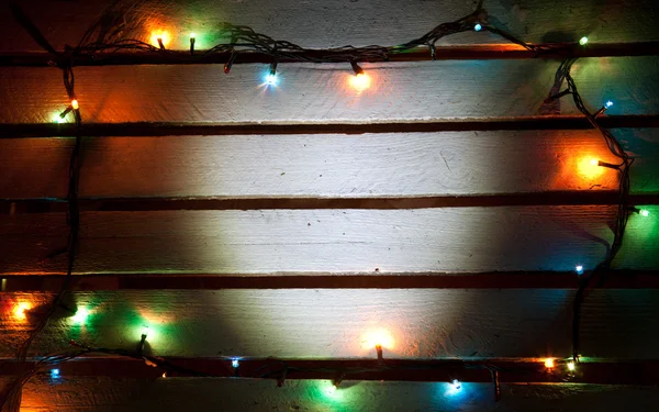 Πολύχρωμο Χριστούγεννα φως σε ξύλινα φόντο με αντίγραφο χώρου — Φωτογραφία Αρχείου