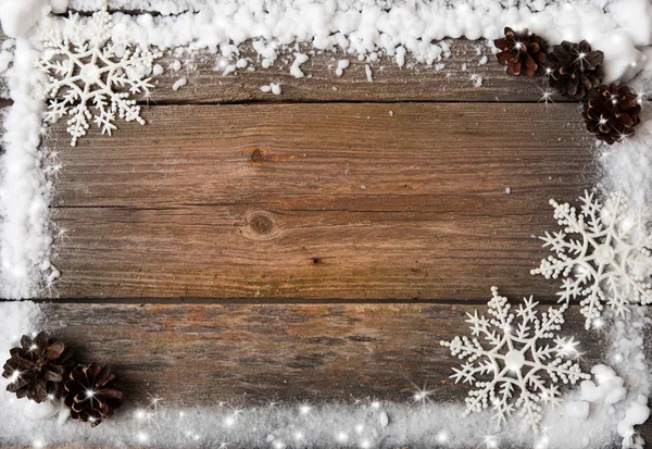 Marco de nieve con copos de nieve y conos sobre fondo de madera, espacio de copia —  Fotos de Stock