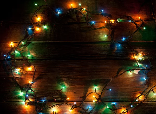 Natal luz colorida no fundo de madeira com espaço de cópia — Fotografia de Stock