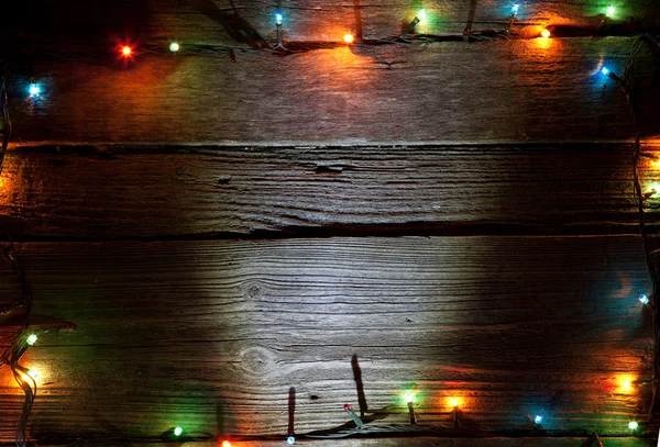 Natal luz colorida no fundo de madeira com espaço de cópia — Fotografia de Stock