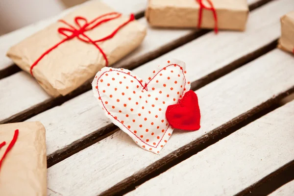 Decorative hearts and gift boxes on white wooden background — Stock Photo, Image