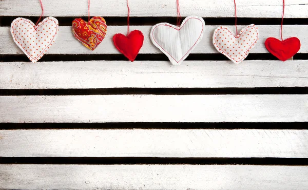 Lot of hearts on white wooden background — Stock Photo, Image
