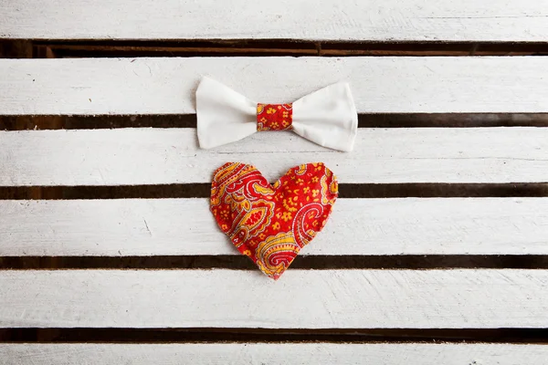 Love hearts with bow tie on wooden planks, copy space — Stock Photo, Image