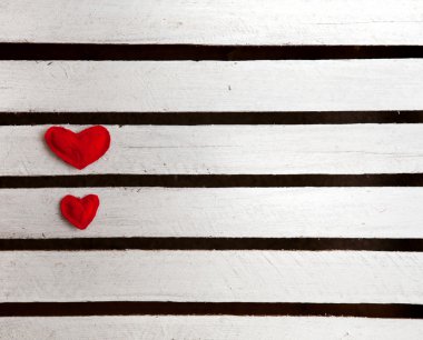 Beyaz ahşap zemin üzerinde iki kırmızı kalp