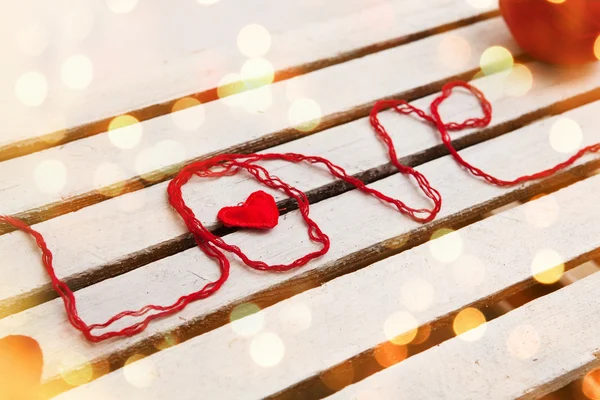 Love word formed with red knitting yarn on wooden background — Stock Photo, Image