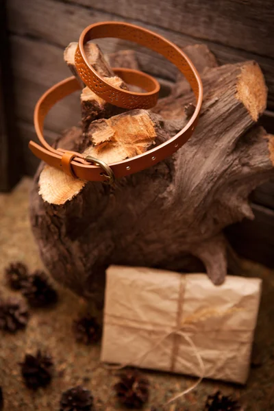 女性と木製の背景にギフトのための茶色の革ベルト — ストック写真