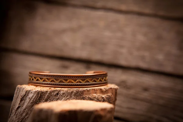 Beautiful expensive gold bracelets on wooden background — Stock Photo, Image