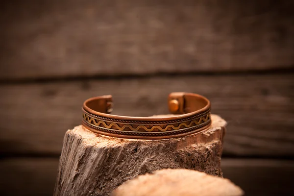 漂亮昂贵的金手链，木制的背景上 图库照片