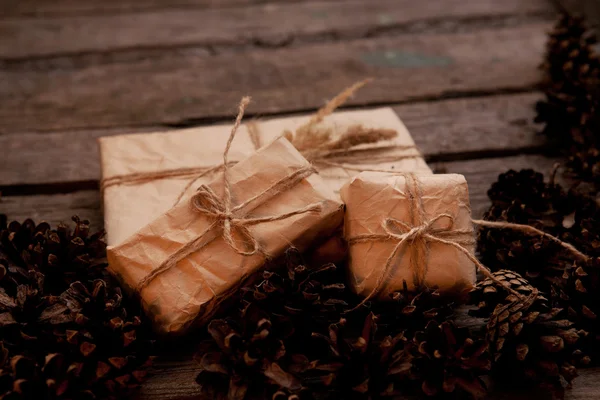 Hadiah antik pada latar belakang kayu dengan kerucut — Stok Foto