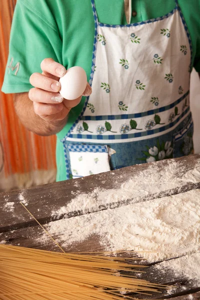 Cocinar a mano agrietando un huevo en una pila de harina . —  Fotos de Stock