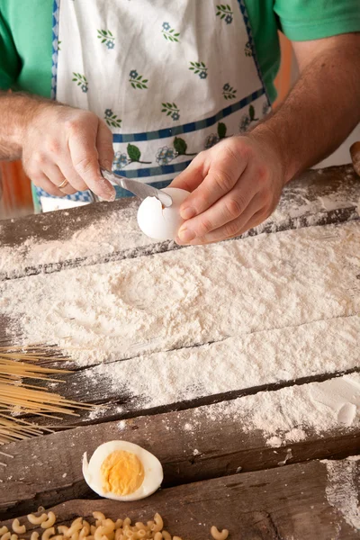 Cocinar a mano agrietando un huevo en una pila de harina . —  Fotos de Stock