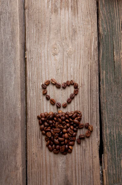 咖啡豆和木制背景上的杯子 图库照片