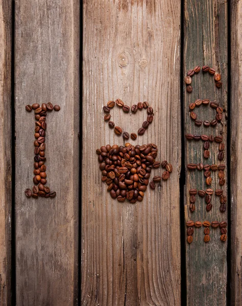 Café en grains et tasse sur fond en bois — Photo