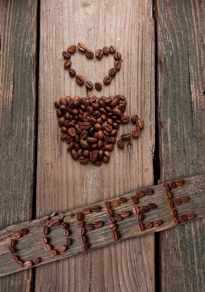 Café en grains et tasse sur fond en bois — Photo