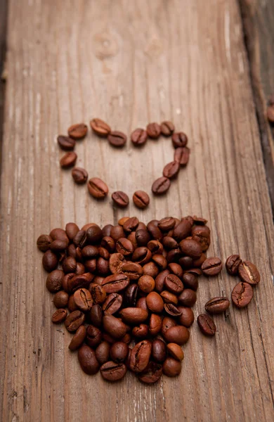 Café en grains et tasse sur fond en bois — Photo