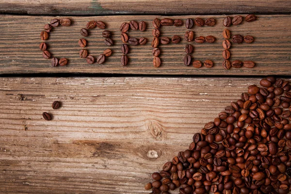 Café en grains et tasse sur fond en bois — Photo