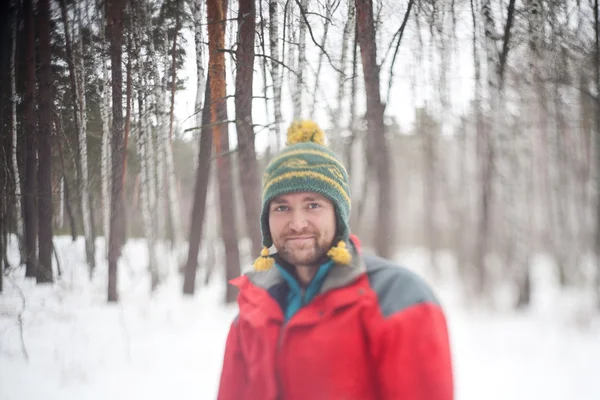 Glada leende ung man i snörik vinter skog — Stockfoto