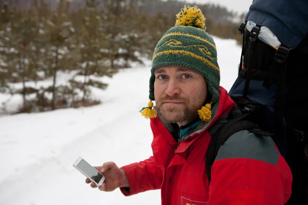 Hombre con teléfono y mapa en manos viajando bosque de invierno —  Fotos de Stock