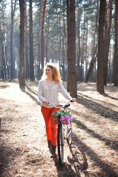 日当たりの良い公園で自転車上で美しい若い女性 — ストック写真